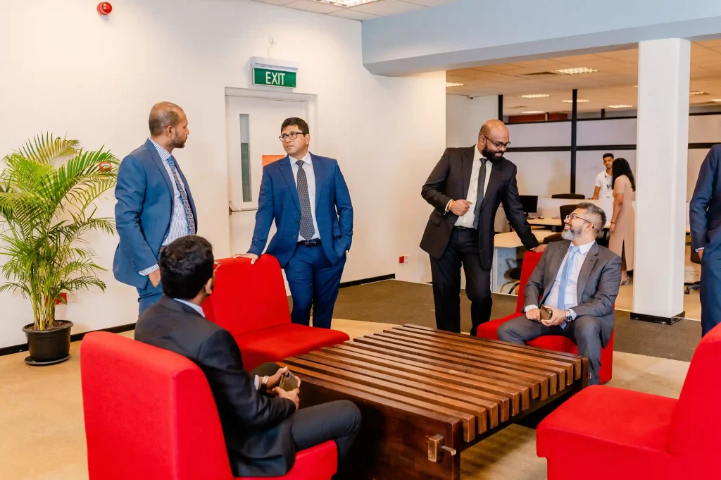 Infomate corporate leadership team interacting in a Colombo office lobby, representing professional business process outsourcing services for B2B clients.