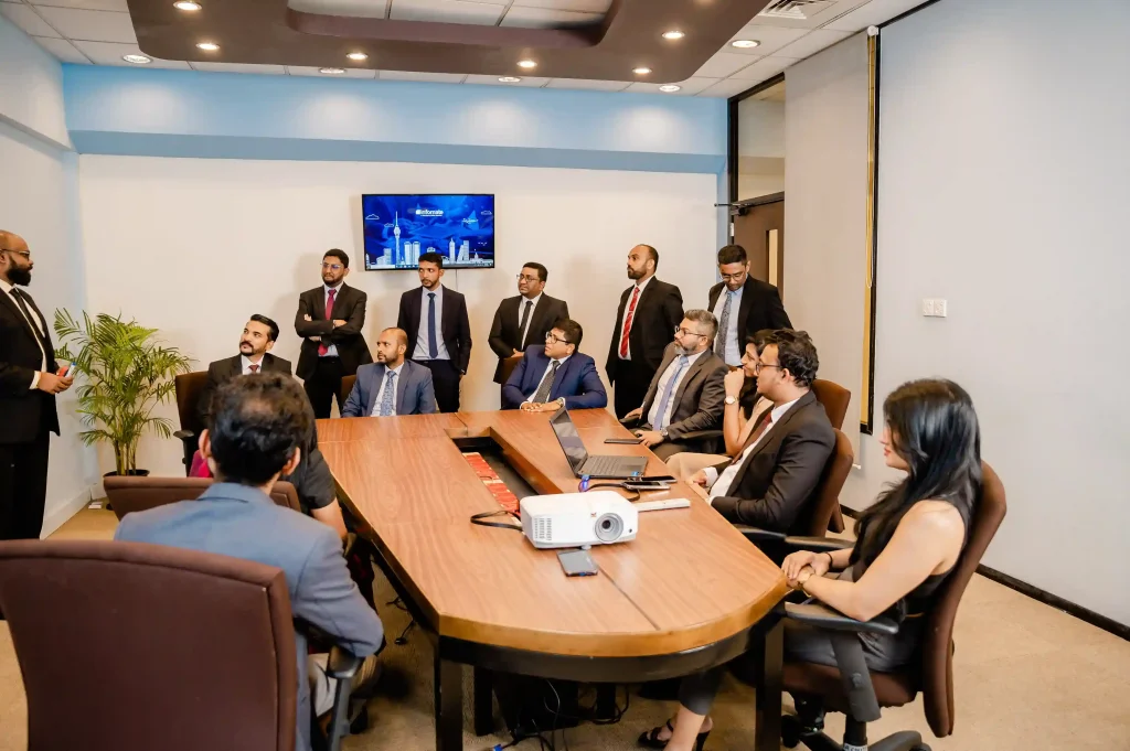 Corporate team members listening to an internal business operations presentation in a modern conference room at Infomate, a leading BPO company in Sri Lanka.