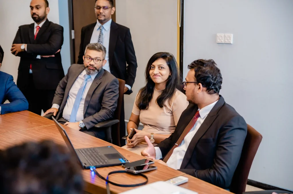 Corporate business professionals collaborating around a conference table during a strategic meeting at Infomate, a leading BPO company in Sri Lanka.