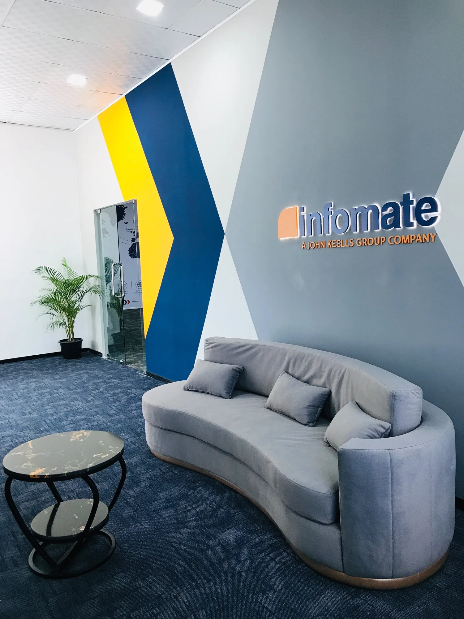 Infomate reception area with the Infomate logo wall and lounge sofa